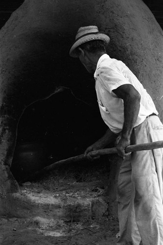 Man operating an oven, La Chamba, Colombia, 1975