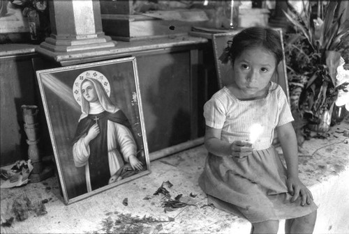 A girl holding a candle in a church, Perquín, 1983