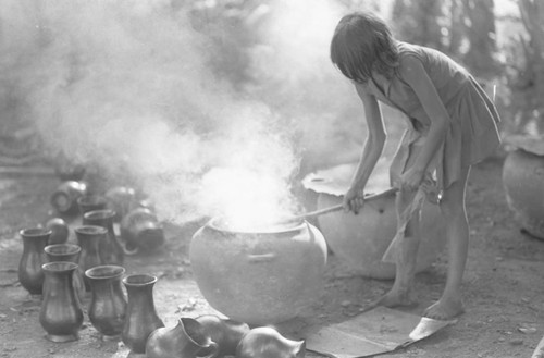 Girl with smoking clay jugs, La Chamba, Colombia, 1975