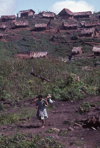 Guatemalan refugee walks with a pail in her hand, Benito Juárez, 1983