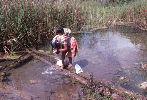 Guatemalan refugee washing her hair in the river, Cuauhtémoc, 1983