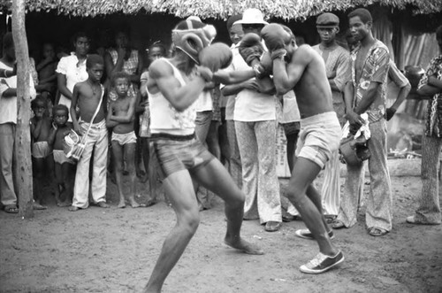 Two men boxing outdoor in front of crowd, San Basilio de Palenque, 1975