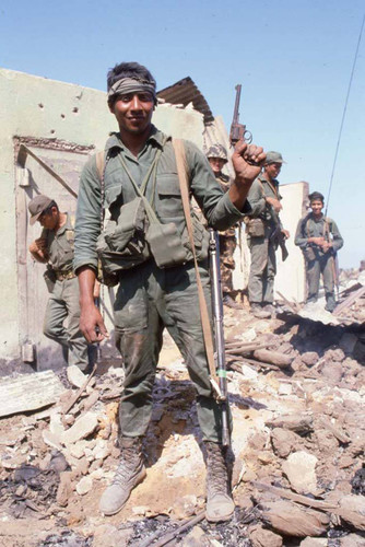 Salvadoran army soldier stands on a destroyed building with a gun in his hand, Berlín, 1983