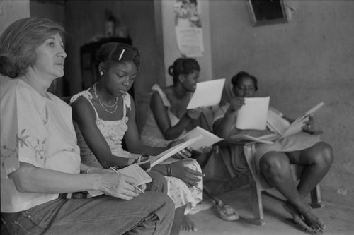 Nina S. de Friedemann and a woman looking at pictures, San Basilio del Palenque, ca. 1978