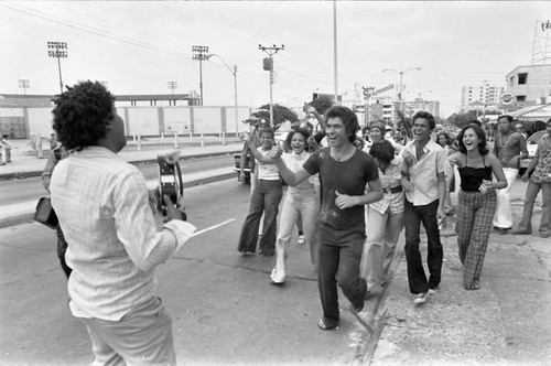 Cameraman filming Carnival participants, Barranquilla, Colombia, 1977