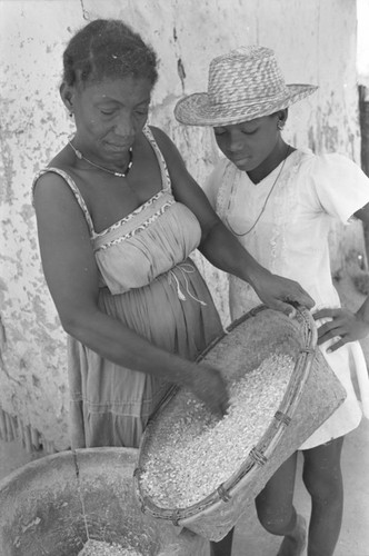 Woman pouring corn into mortar, San Basilio del Palenque, ca. 1978