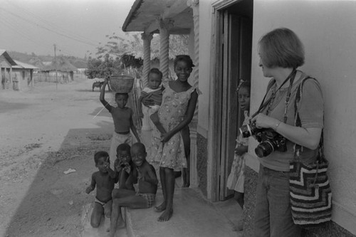 Anthropologist and group of children standing in front of a house, San Basilio de Palenque, ca. 1978