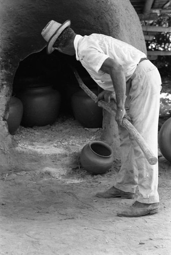 Man operating an oven, La Chamba, Colombia, 1975