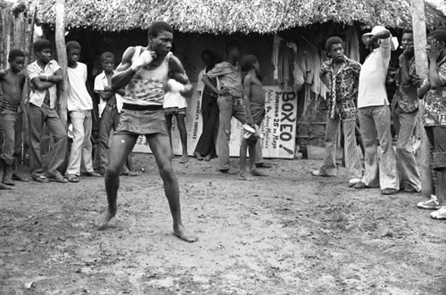 Man boxing outdoor in front of a crowd, San Basilio de Palenque, 1975