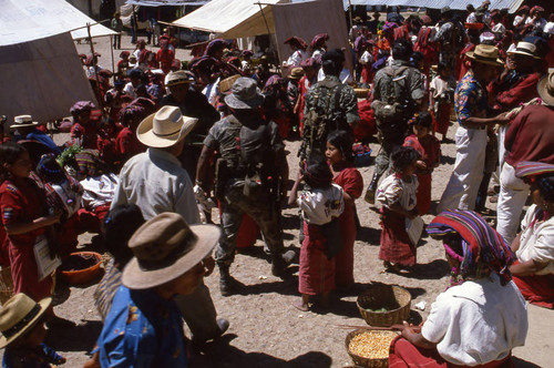 Three soldiers walking through a market, Chajul, 1982