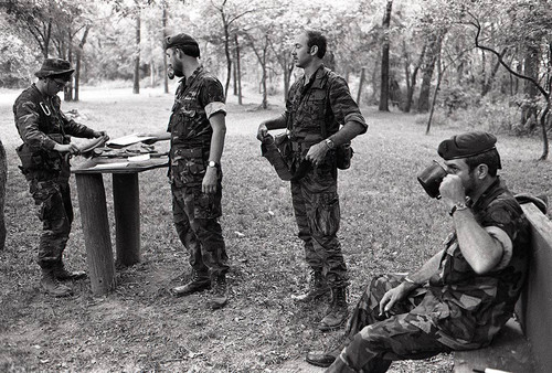 Survival school students stand near Harry Claflin and an assistant, Liberal, 1984