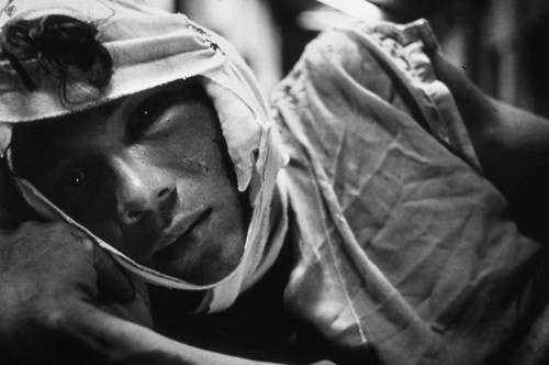 Injured man in bed, Nicaragua, 1979