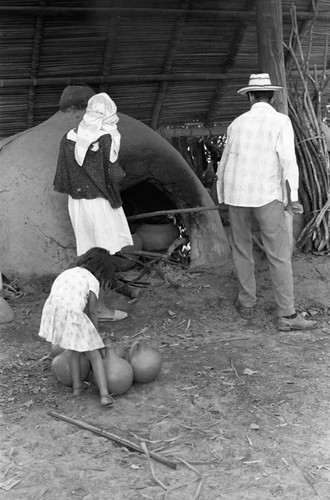 Man operating an oven, La Chamba, Colombia, 1975