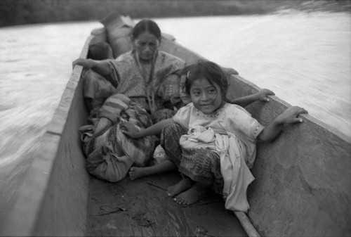 Refugee woman and three children in a canoe, Chiapas, 1983