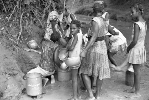 Women and girls collect water at river, San Basilio de Palenque, 1975