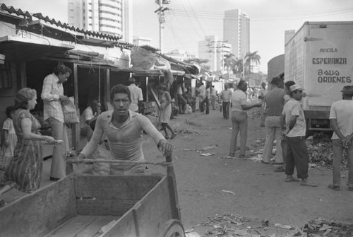 Man pushing cart at city market, Cartagena Province, ca. 1978