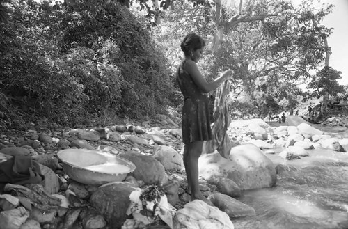 Woman washing clothes near river, La Guajira, Colombia, 1976