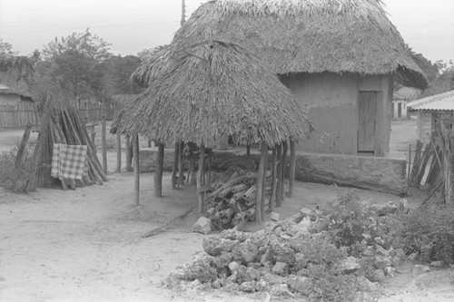 Wood stacked under a palapa, San Basilio de Palenque, 1976