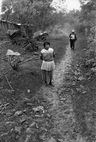 Refugee woman outside huts, Chiapas, 1983