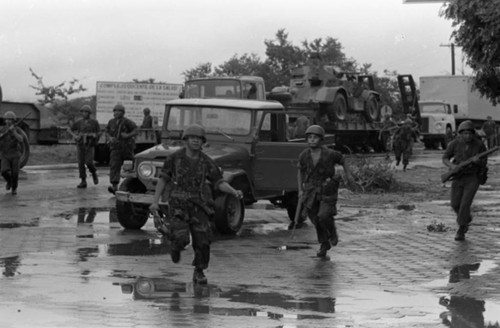 Soldiers run in the street, Nicaragua, 1979