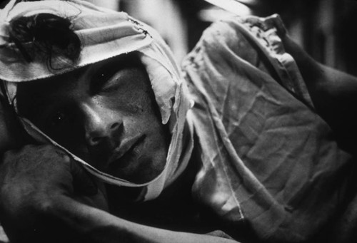 Injured man in bed, Nicaragua, 1979