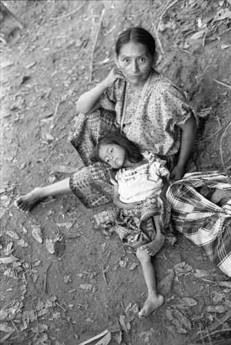 Refugee woman and a girl sit at a river, Chiapas, 1983