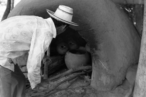 Man operating an oven, La Chamba, Colombia, 1975