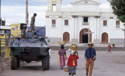 Army tank patrols a street near a church, Chimaltenango, 1982