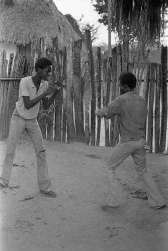 Boys boxing in front of a fence, San Basilio del Palenque, ca. 1978