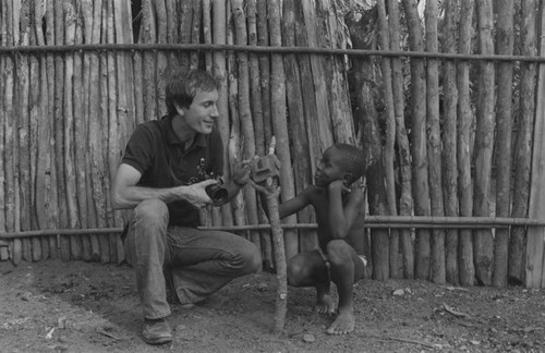 Richard Cross and a boy examining a toy camera, San Basilio de Palenque, 1977