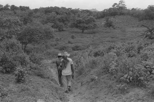 Two men carrying yucca roots, San Basilio de Palenque, 1975