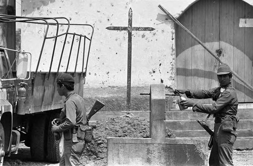 A soldier refills his canteen, Morazán, 1983