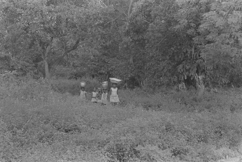 Girls walking with metal container on their head, San Basilio de Palenque, 1976