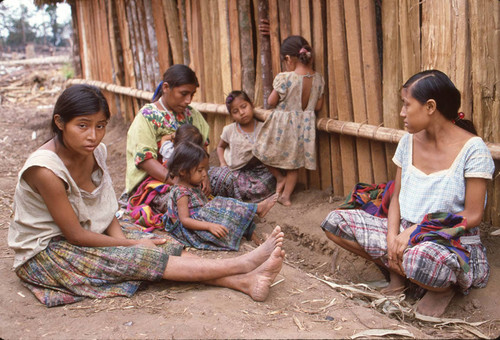 Guatemalan refugees outside a hut, Chajul, ca. 1983