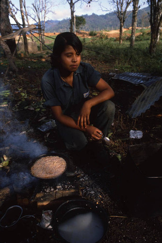 A female Contra soldier cooks food for the camp, Nicaragua, 1983