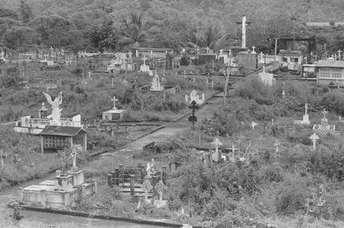 Distant view of a man landscaping a cemetery, Barbacoas, Colombia, 1979