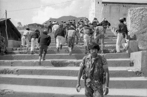 Mayan men running up the stairs during a military training exercise, Chajul, 1982