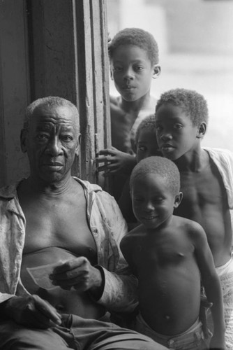 Fermín Herrera sitting by a door, San Basilio de Palenque, 1976