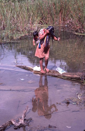 Guatemalan refugee washing her hair in the river, Cuauhtémoc, 1983