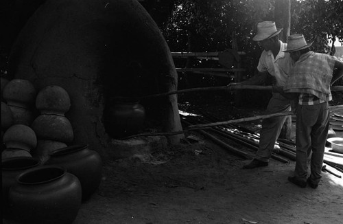 Men working the clay oven, La Chamba, Colombia, 1975