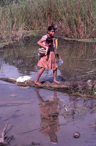 Guatemalan refugee washing her hair in the river, Cuauhtémoc, 1983