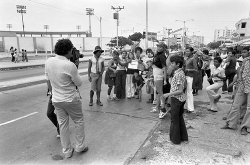 Cameraman filming Carnival participants, Barranquilla, Colombia, 1977