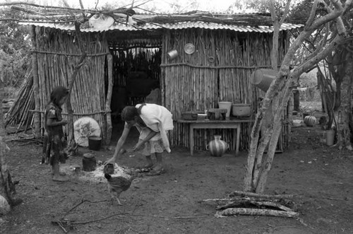 Refugee woman holds a baby in a hut, Chiapas, 1983