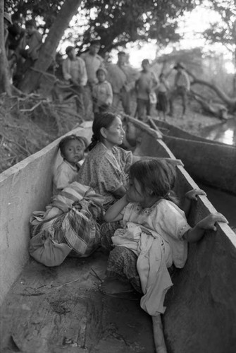 Refugee woman and three children in a canoe, Chiapas, 1983