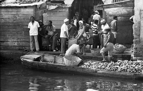 Men unload bananas from a boat, Cartagena Province, 1975