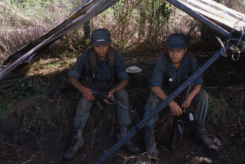 Two child Contra soldiers sit under a tent, Nicaragua, 1983