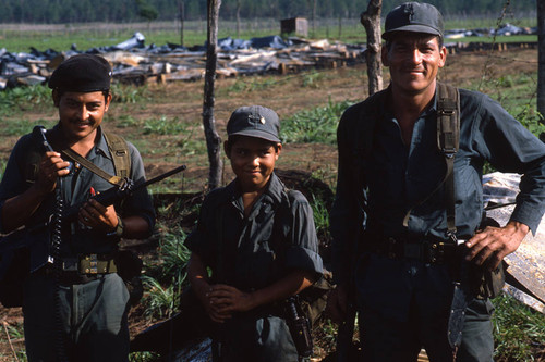 A child soldier stands between two older Contras at El Porvenir Farm, Nicaragua, 1983