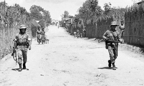 Soldiers patrol a village, Guatemala, 1982