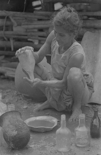 Woman working with bottles, La Chamba, Colombia, 1975