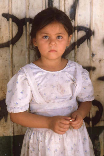 A girl in a white dress holds a bullet in her hands, San Agustín, 1983